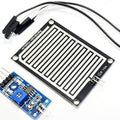 Rain Drops Detection Sensor Module In Paksitan - a black rectangular sensing board connected by wires to a blue control board with a potentiometer.