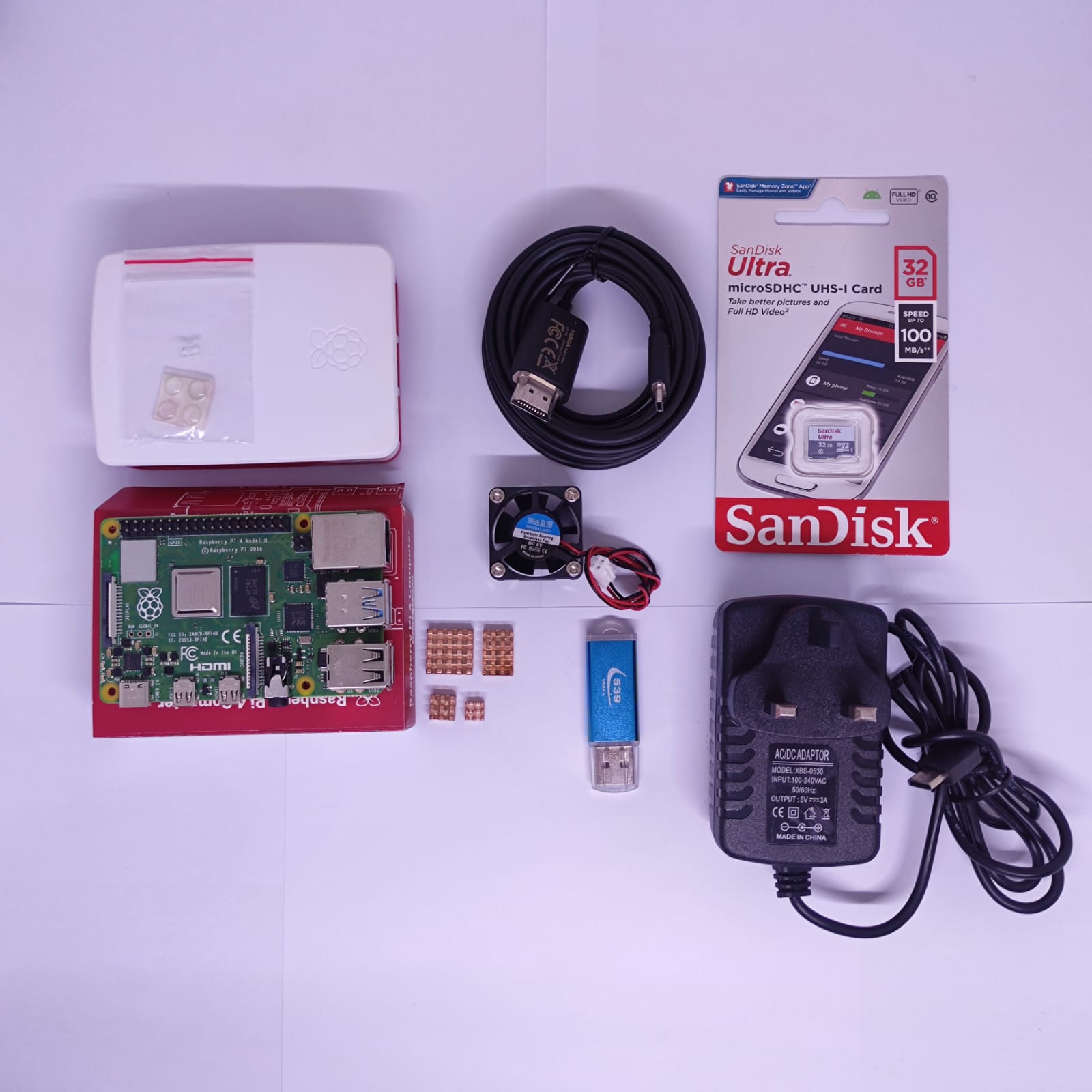 Raspberry Pi 4 8GB RAM Starter Kit - a circuit board, white case, cooling fan, heatsinks, HDMI cable, 32GB microSD card, USB drive, and power adapter.