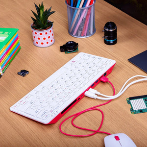 Raspberry Pi 400 4GB RAM Your Complete Personal Computer, Built Into a Compact Keyboard-digilog.pk - a white and red keyboard computer connected to a white mouse and a green circuit board on a wooden desk.