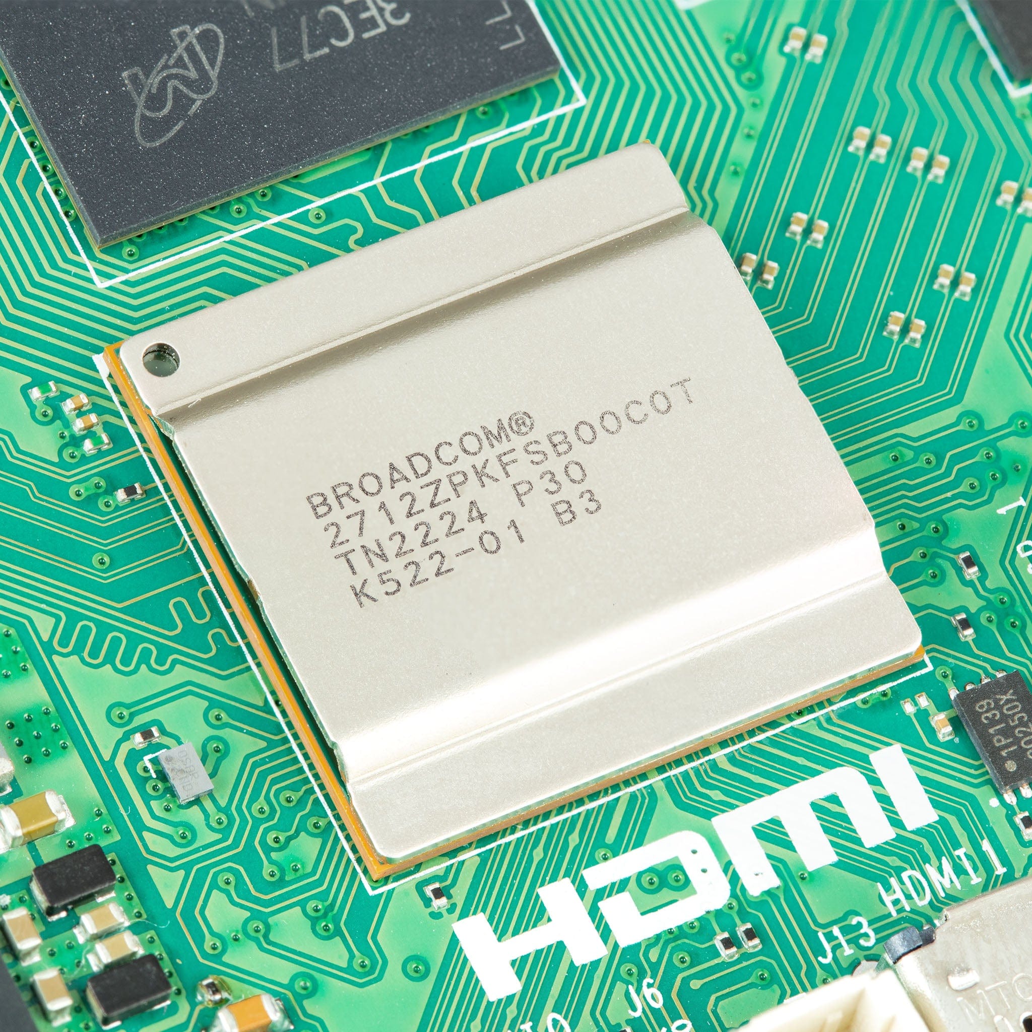 Raspberry Pi 5 4GB - the Broadcom processor with a metal heat spreader on a green circuit board next to an HDMI port label.