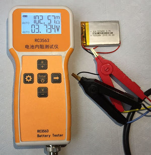RC3563 Battery Internal Resistance Tester - an orange handheld device with a display reading 102.57mΩ and 3.734V, connected to a lithium battery.