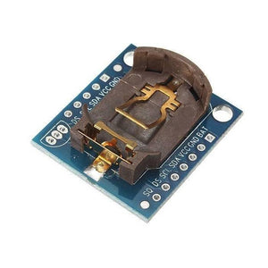 Real Time Clock DS1307 Ds 1307 RTC I2c Module AT24C32 - with AT24C32, showing a blue rectangular circuit board with a brown coin cell battery holder and two rows of pin headers.