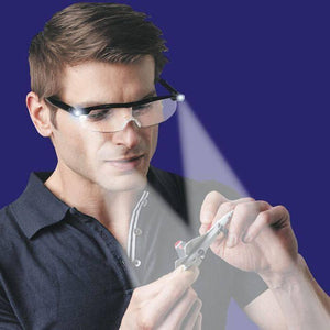 Rechargeable LED Magnifying Glasses - shown being worn by a man who is using the integrated LED lights to inspect a small model airplane.