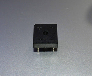 Rectron Bridge Ractifier BR104 (used Condition) - a black, square-shaped electronic component with four metal pins and symbols for positive and AC inputs on its surface.