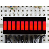 Red 10-Segment LED Bar Graph Display – Audio VU Meter, Power & Signal Level Indicator Module - a close-up of a rectangular module with ten illuminated red light segments mounted on a white breadboard.