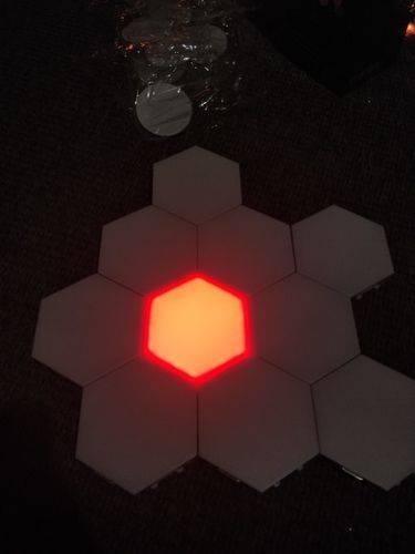 Red Touch Light Wall Mount Magnetic Modular (1pc) - a single red illuminated hexagonal light panel surrounded by six unlit white hexagonal panels.