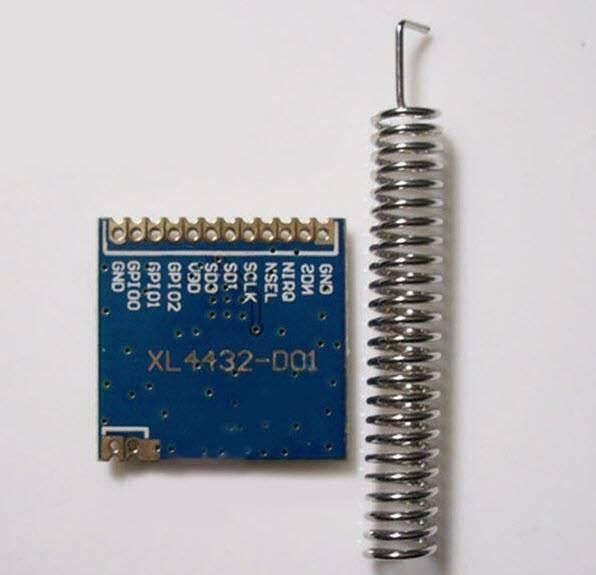 Retired Product XL4432-SMT SI4432 Wireless Transceiver Module - a blue square circuit board with pin labels and a separate silver helical spring antenna.