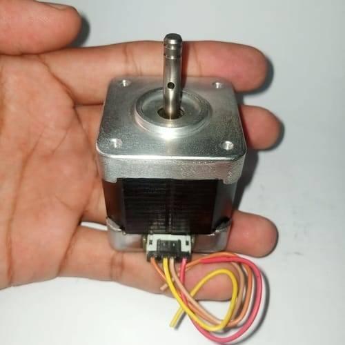 Round Shaft NEMA17 Stepper Motor For 3d Printer & CNC - held in a hand, showing the silver metal top, black body, vertical shaft with a hole, and a white connector with wires.