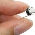 Round Tactile Micro Push Button Switch - a small black circular base with a white center button and two long metal pins.