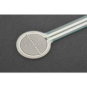 RP-C18.3-LT Thin Film Pressure Sensor - a close-up showing a circular white sensor pad with a silver spiral pattern connected to a flat ribbon cable.