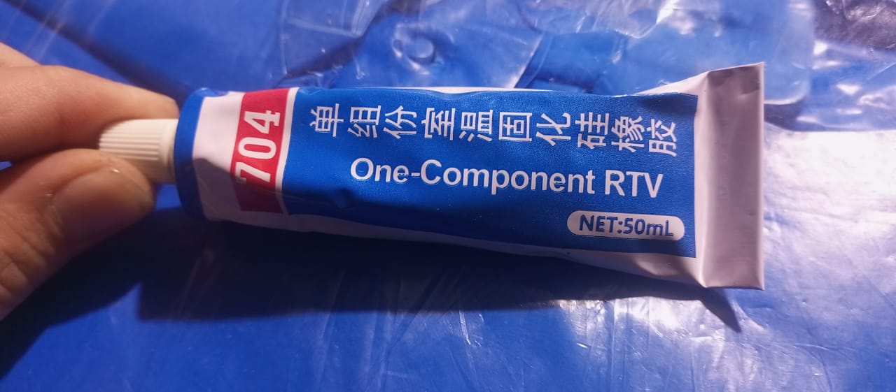 Rtv 50ML Tube Motherboard Insulation Glue Paste - shown as a blue and white 50mL squeeze tube held by a hand against a blue background.