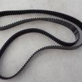 S5M1420 Timing Belt - a black, toothed rubber belt looped in a figure-eight shape on a light-colored surface with visible white text markings.