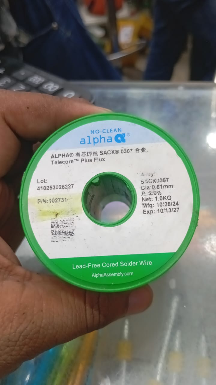 SACX0307 Alpha Lead Free Solder Wire - shown as a close-up of a green plastic spool with a white label detailing product specifications and dates.