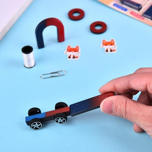 Science Magnets Set for Kids | Educational Classroom Experiment Kit - a hand holding a magnetic toy car near a horseshoe magnet, ring magnets, paperclip, and fox stickers on a blue surface.