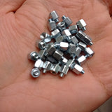 Screw Standoffs Spacers M3 Male x M3 Female - shown as a pile of small, silver-colored metal hexagonal standoffs held in a person's palm.