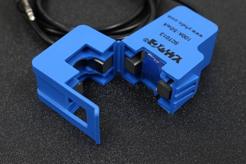 SCT013-000 Ct 100A Non-invasive AC Current Sensor - shown open to reveal its blue plastic casing, internal magnetic core, and attached 3.5mm audio jack cable.