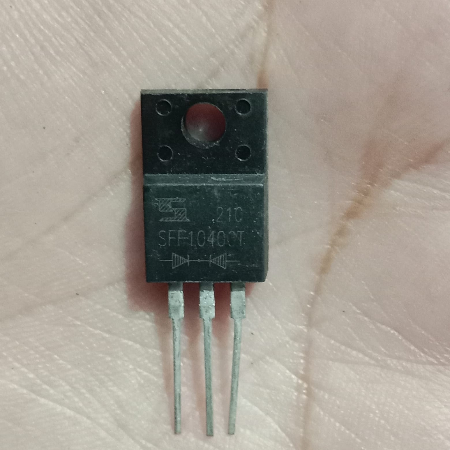 SFF10400CT Dual Fast Recovery Rectifier Diode, 10A 400V (TO-220F, Common Cathode) - shown as a black, three-pin electronic component in a TO-220F package held against a palm.