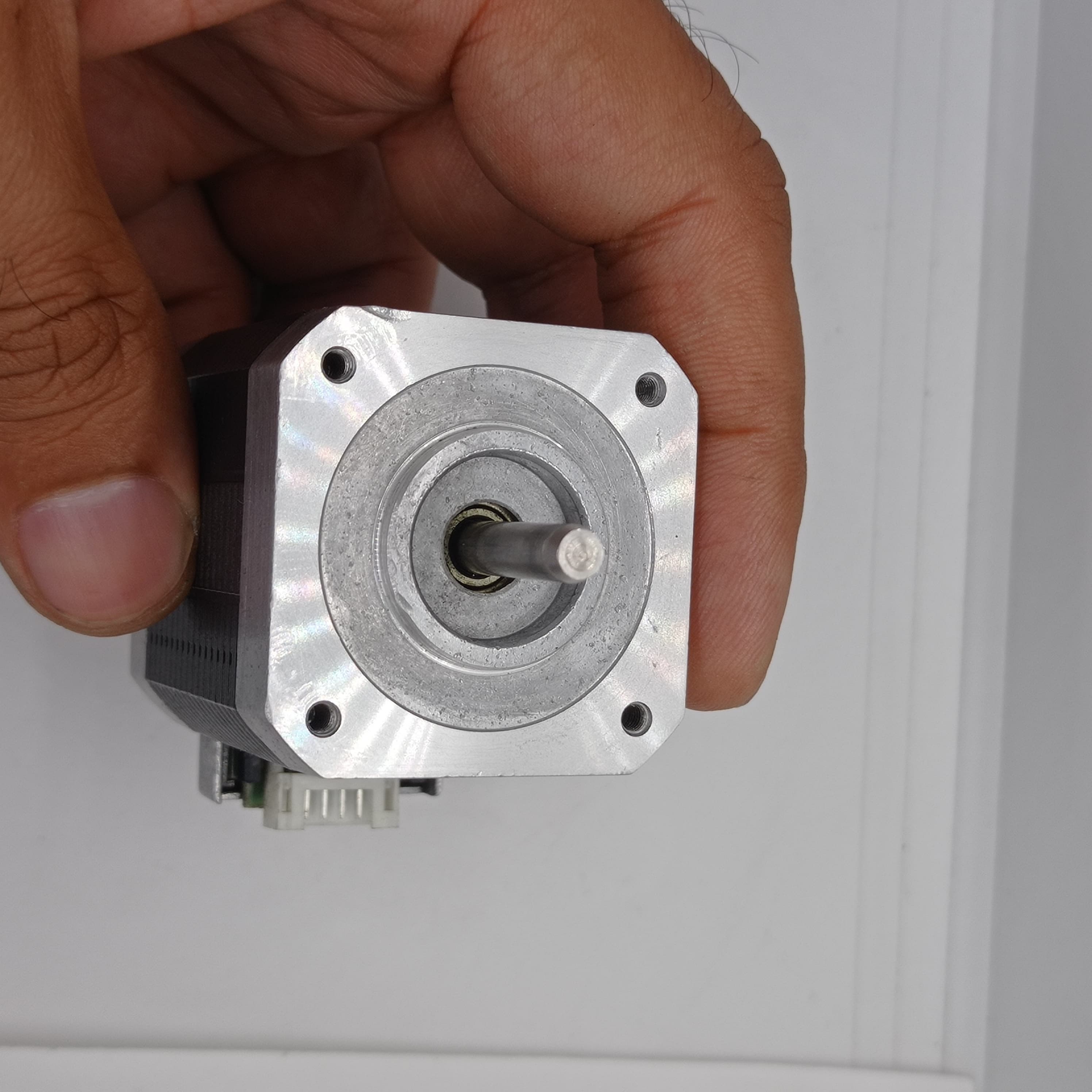 Shinano Kenshi STP-42D4042 2A 1.8 Degree Per Step 0.53nm Stepper Motor - close-up view of the silver metal front face, circular mounting flange, central rotating shaft, and connector.