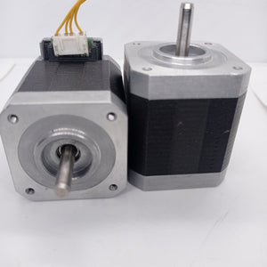 Shinano Kenshi STP-42D4042 2A 1.8 Degree Per Step 0.53nm Stepper Motor - two silver and black square-bodied motors, one with a white electrical connector and yellow wires attached.