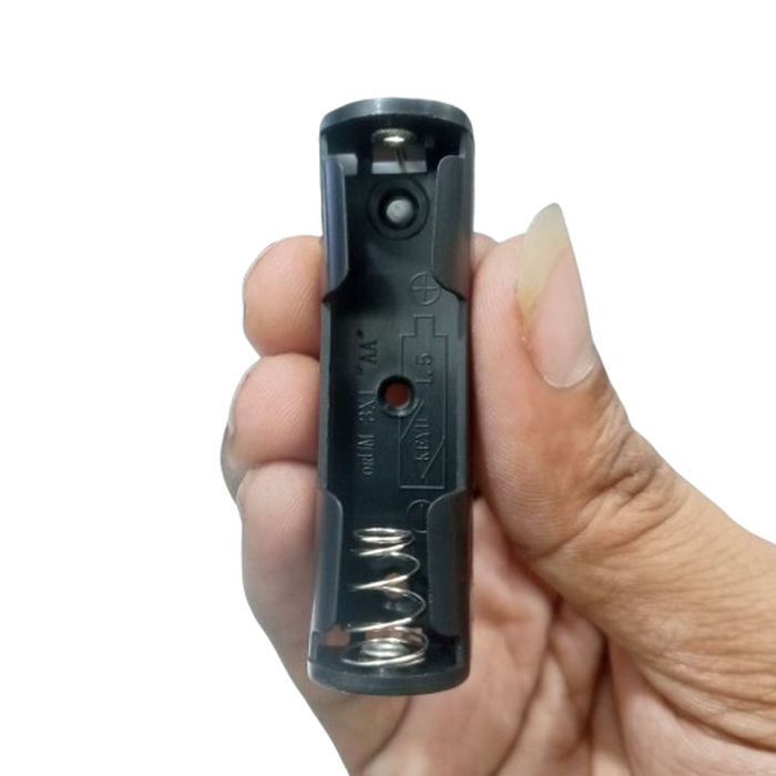 Single 1 AA Battery Holder, 1 x 1.5V AA Battery Holder - a black plastic casing held in a hand, featuring a metal spring contact at one end and a positive terminal at the other.