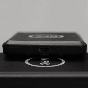 Smart Card Reader AND WRITER Recorder RFID IC Copier, NFC Duplicator, 13.56MHz - a close-up of the black device's side profile with a micro-USB port resting on a surface marked with an NFC logo.