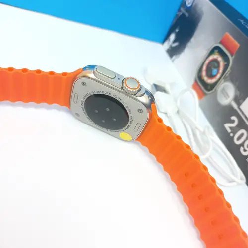 Smart Watch T900 Ultra 2.09 Inch Big Display Bluetooth Calling Series 8 With All Sports Features & Health Tracker - Smart Watch Ultra Infinite Display - the orange silicone strap, the rear sensor casing, side buttons, and the charging cable with its retail box in the background.