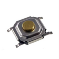 SMD Tactile Switch, 4x4x1.5mm - a close-up view of a small square silver-coloured metal tactile switch with a round gold-coloured button in the center.
