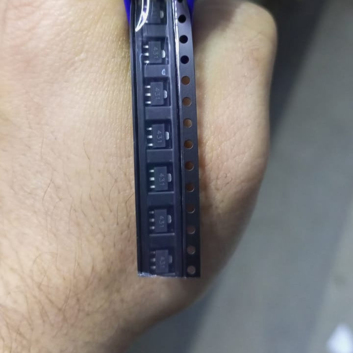 SMD TL431 431 CJ431 SOT89 - shown in a close-up view as a strip of black electronic components held in a hand.