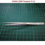 SMD Tweezer Vanal v 11 For Positioning Components - a silver-colored, pointed metal tweezer lying horizontally on a green cutting mat.
