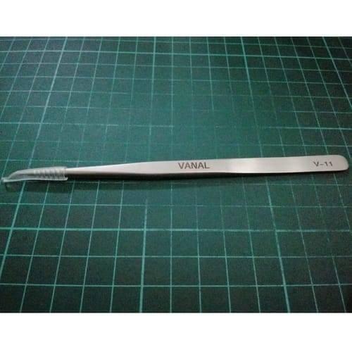 SMD Tweezer Vanal v 11 For Positioning Components - a silver-coloured metal tool with a protective plastic tip cover, lying horizontally on a green cutting mat.