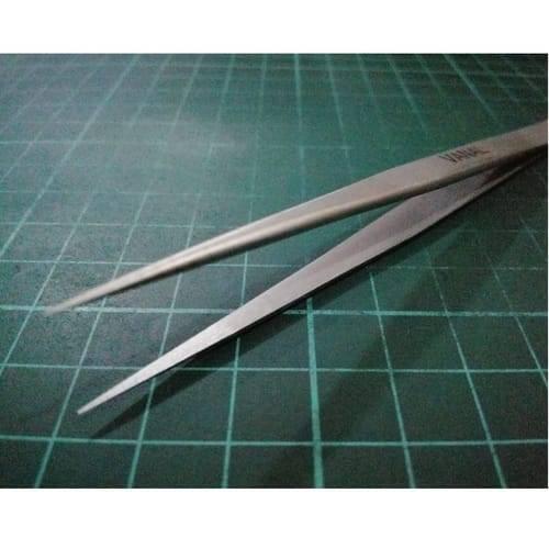 SMD Tweezer Vanal v 11 For Positioning Components - a pair of silver-toned, pointed metal tweezers resting on a green grid-patterned cutting mat.