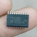 SN74HC244 SMD IC - held between fingers, showing a black rectangular surface-mount integrated circuit with 20 pins and the text 74HC244D printed on top.
