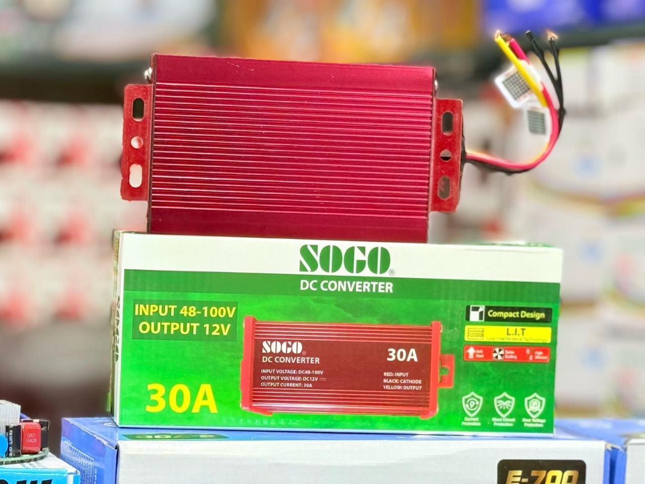 SOGO 30A DC Converter | 48-72V to 12V Step Down Voltage Regulator - a red rectangular voltage regulator with wires, sitting on top of its green and white product packaging box.
