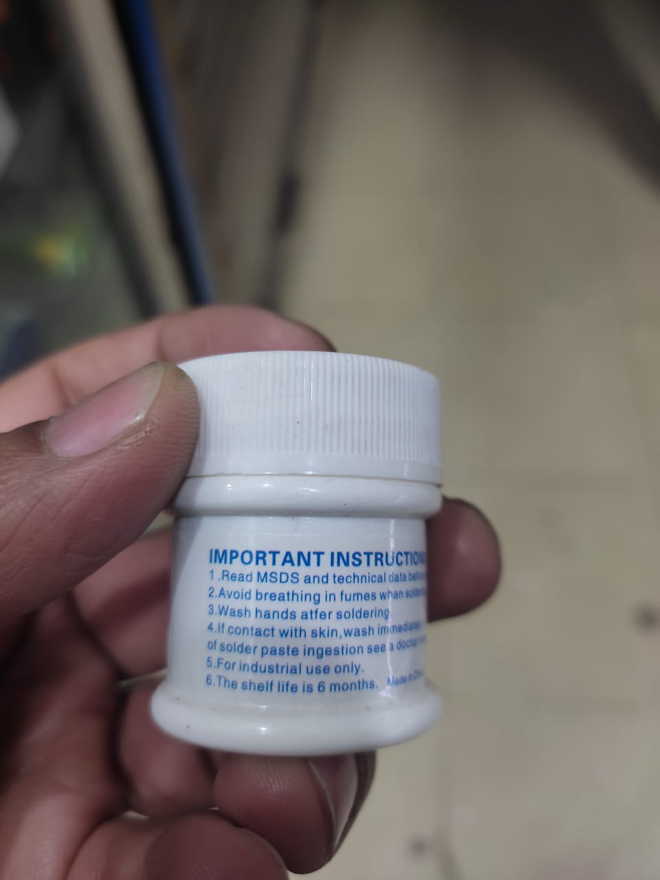 Solder Paste (183°C) MaAnt Model MY-83A Weight 50G - a small white plastic jar held in a hand, showing the printed important instructions label on its side.