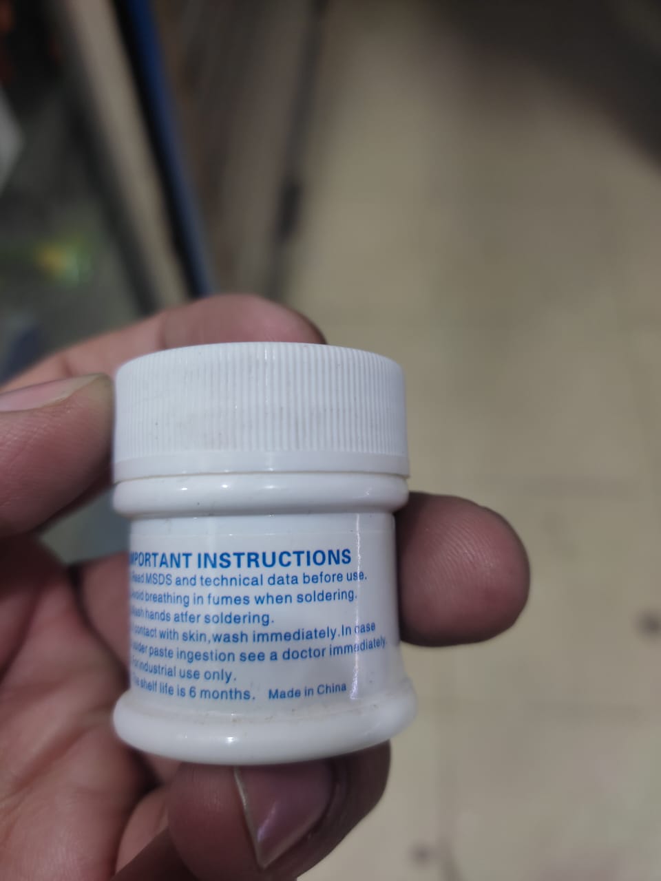 Solder Paste (183°C) MaAnt Model MY-83A Weight 50G - a small white plastic container held in a hand, showing the printed important instructions label on its side.