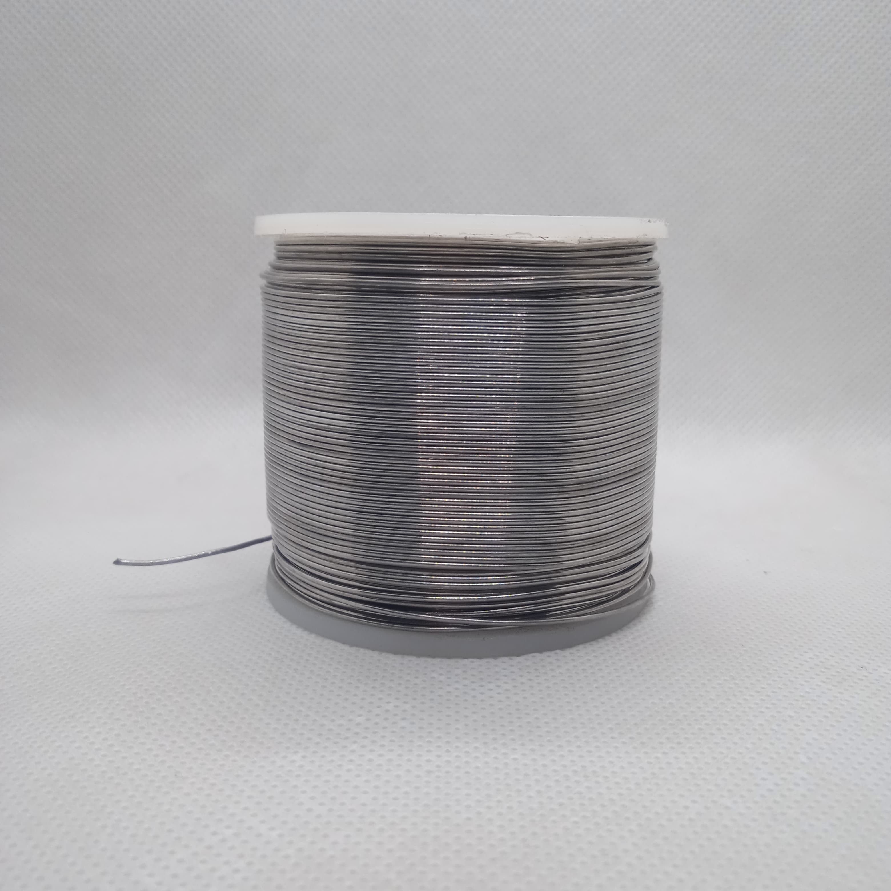 Solder Wire - High Quality 63-37 Professional Solder 400G | digilog.pk - shown as a large spool of thin, silver-colored metal wire wound around a cylindrical core.