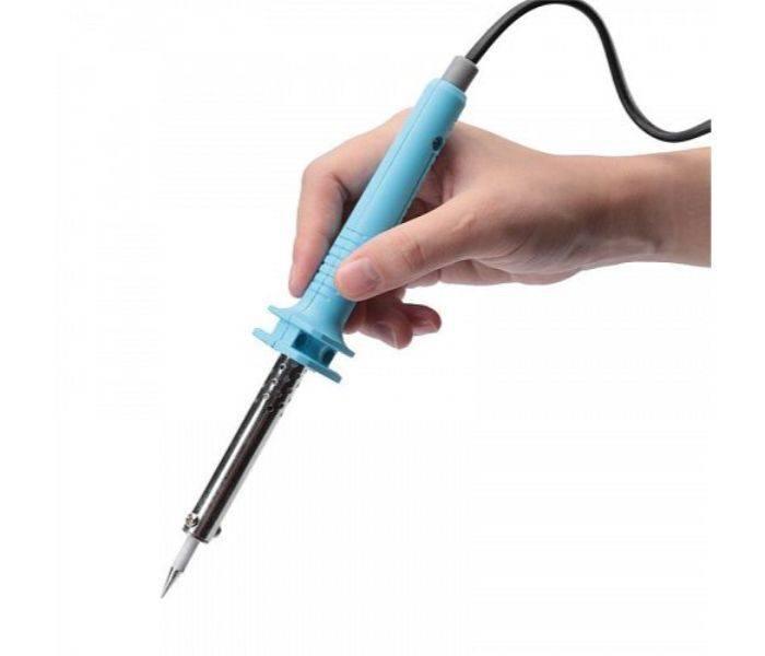 Soldering Iron 60watt - shown being held by a hand, featuring a light blue plastic handle with a metallic heating element and a pointed tip.
