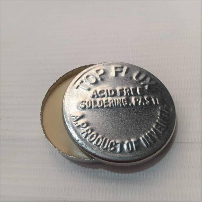 Soldering Paste - small, round, silver-coloured metal tin with the text "TOP FLUX ACID FREE SOLDERING PASTE" embossed on the lid.
