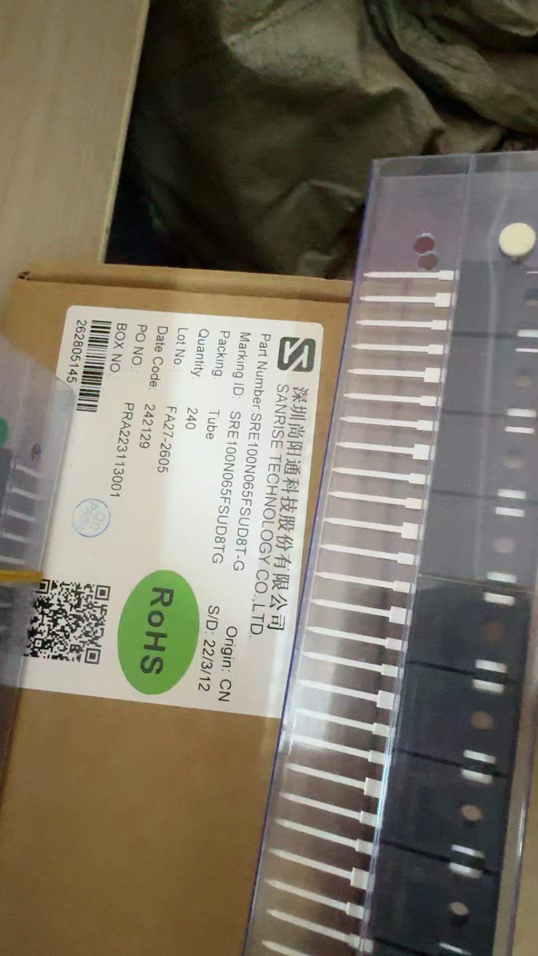 SRE100N65 IGBT - High-Performance Transistor for Power Electronics - a row of silver-coloured metal transistors in a clear plastic tube resting on a cardboard box with a product label.