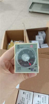 (st3p A-b) Analogue Timer/time Delay Relay - a circular dial marked 0-10 SEC, an adjustment knob, UP and ON indicator lights, and cardboard boxes.