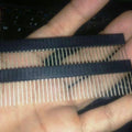 Stackable Arduino Female Header Strip - shown as two parallel rows of long, thin metal pins held together by black plastic strips held in a hand.