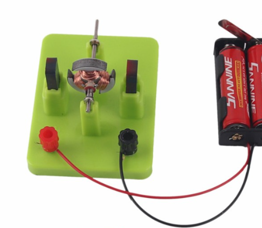 STEM DIY DC Electrical Motor Model - Physics Experiment Learning Toy - a green plastic motor base with a copper coil armature, two magnets, and a battery holder connected by wires.