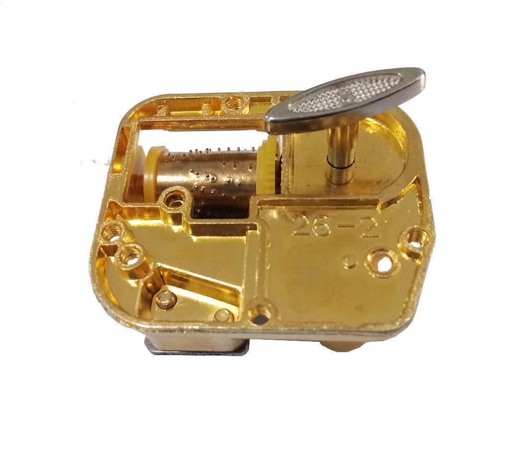 STEM Toy 18 Note Mechanical Music Box Music Movement Set - a gold-colored mechanical movement with a winding key and a pinned cylinder.