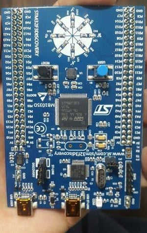 Stm Discovery Kit STM32F3 STM32F303VC With Programming Cable - a blue rectangular development board featuring a central microcontroller, eight LEDs, two buttons, and two USB ports.