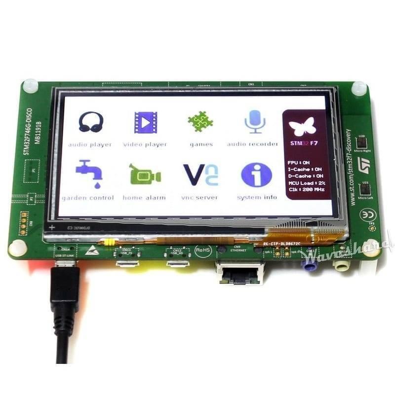 STM32F746G Disco Discovery Board Kit - a green circuit board with a touchscreen display showing a menu of icons and a connected USB cable.