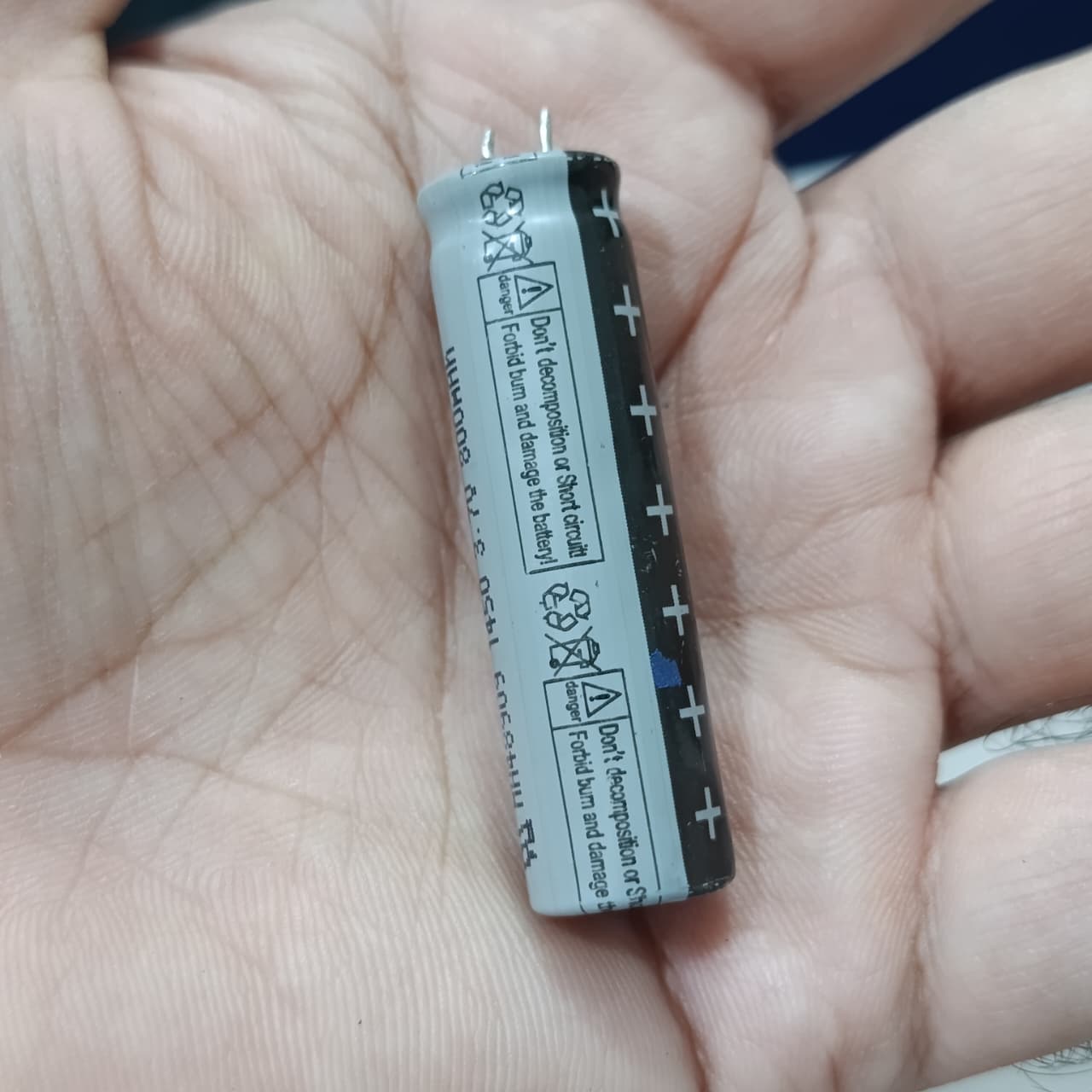 Stock Lot 3.7V 800mAh Lithium Battery 14mm x 50mm 2-Pin Rechargeable (Li-ion Cylindrical Cell) - grey and black battery with two metal pins held in a hand.