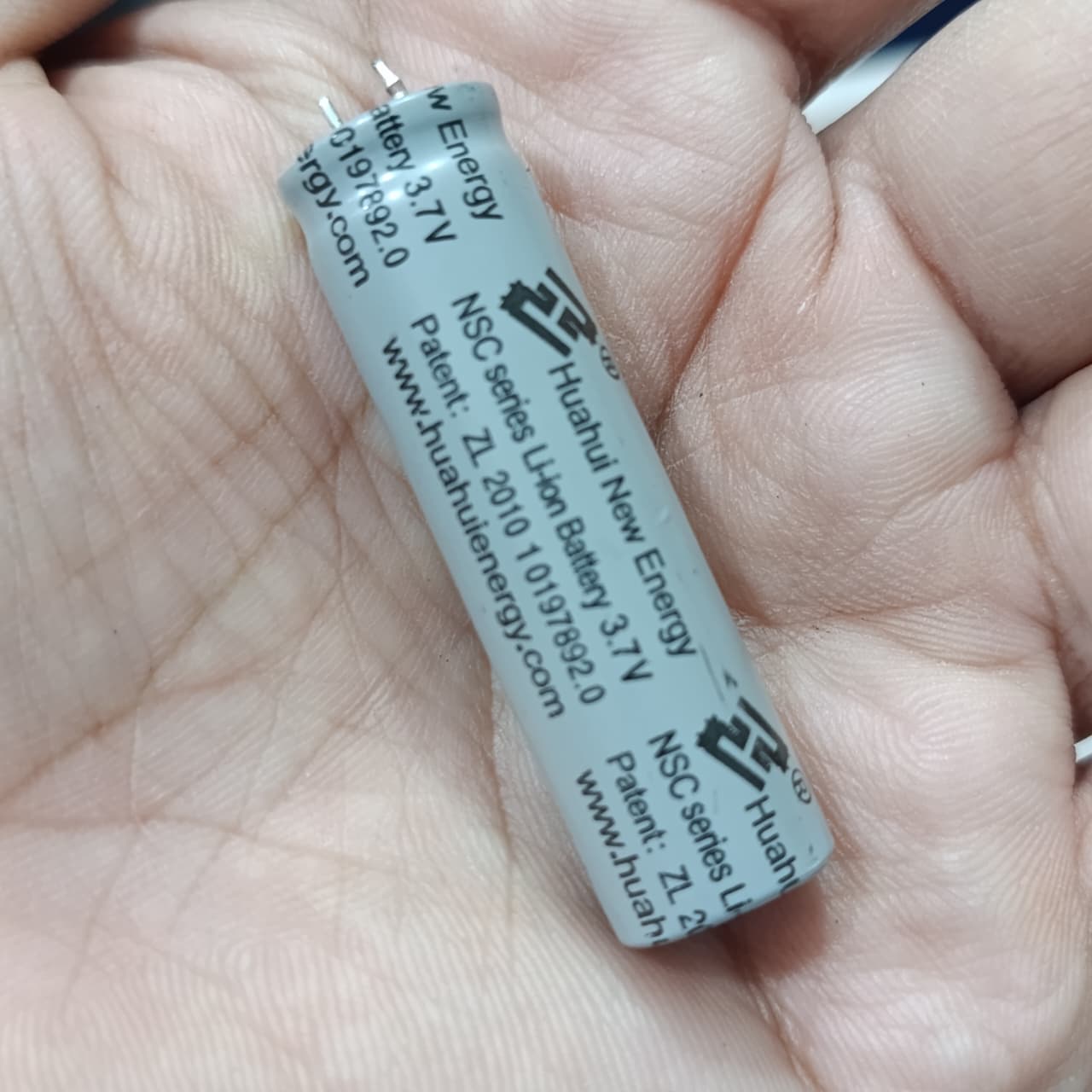 Stock Lot 3.7V 800mAh Lithium Battery 14mm x 50mm 2-Pin Rechargeable (Li-ion Cylindrical Cell) - a close-up of a grey cylindrical Li-ion cell held in a hand, showing printed text.