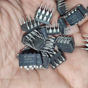 Stock Lot LM2574 Adj Voltage Buck Regulator IC - a pile of black, 8-pin integrated circuit chips held in a hand, showing the printed model and batch markings.