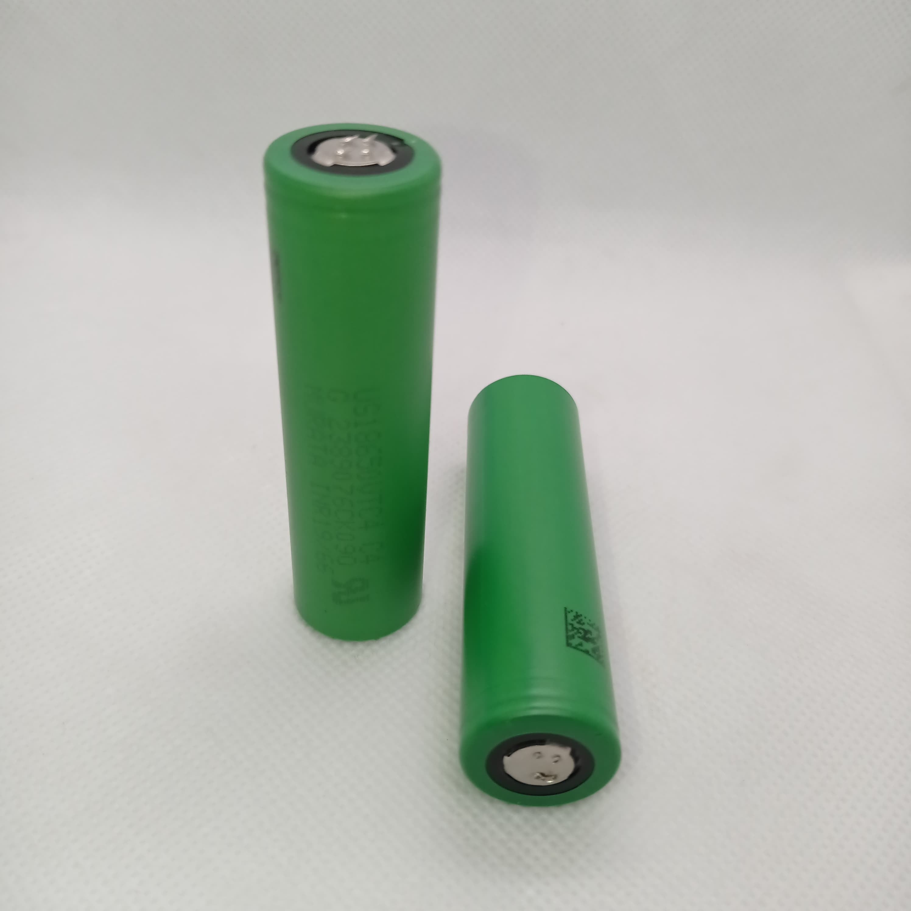 Stock Lot US18650UTC4 3.7V 2000mA 18650 Li-ion Rechargeable Battery – High-Capacity Power Cell for Flashlights, Laptops, and Power Tool - two green cylindrical batteries standing upright against a white background.