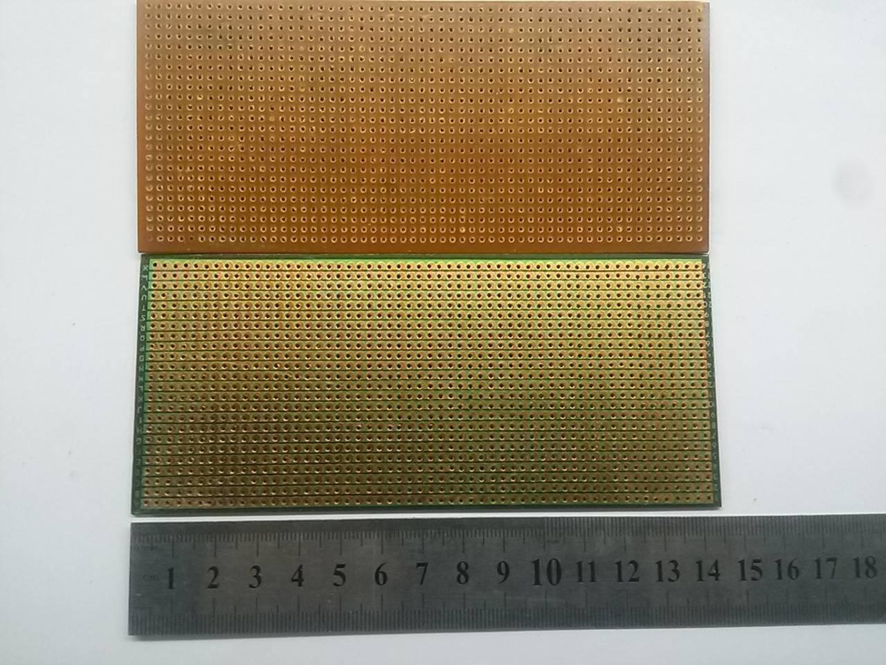 Stripbaord Veroboard Straight Lined Small - shown as two rectangular circuit boards with copper strips and holes, positioned above a metal ruler.